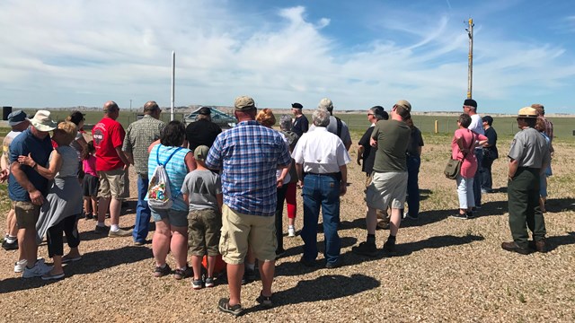 A volunteer leads a group program inside of a fenced enclosure