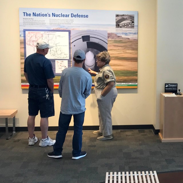 Volunteers interact with small groups of visitors in a lobby