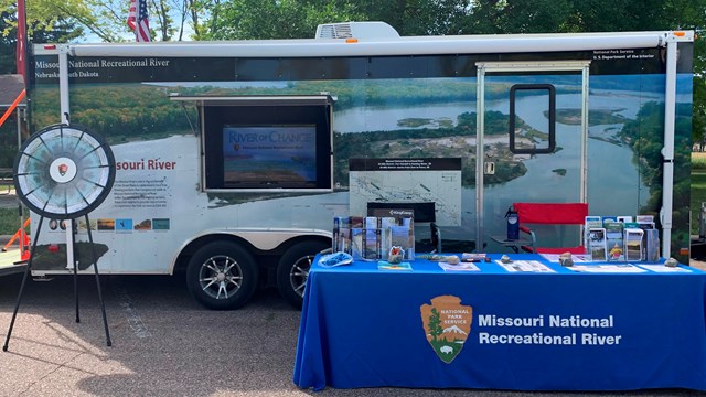 Mobile Ranger Station set up at an event with a pop-up table and a prize wheel.