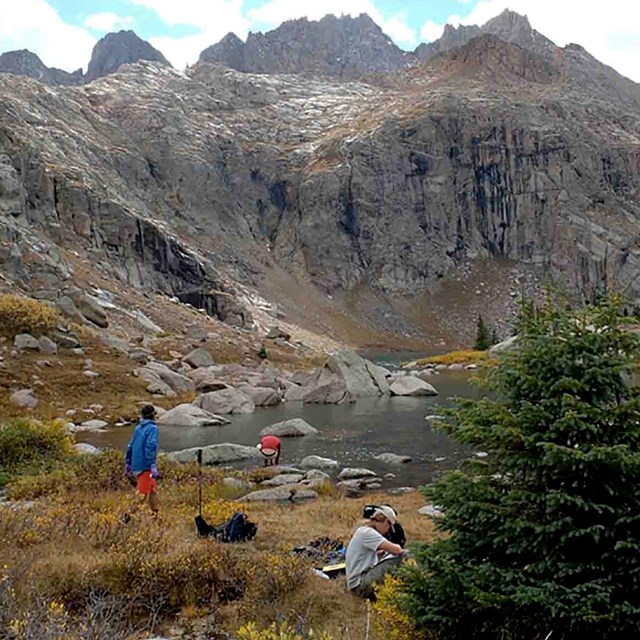 A group of students work in a mountain valley.