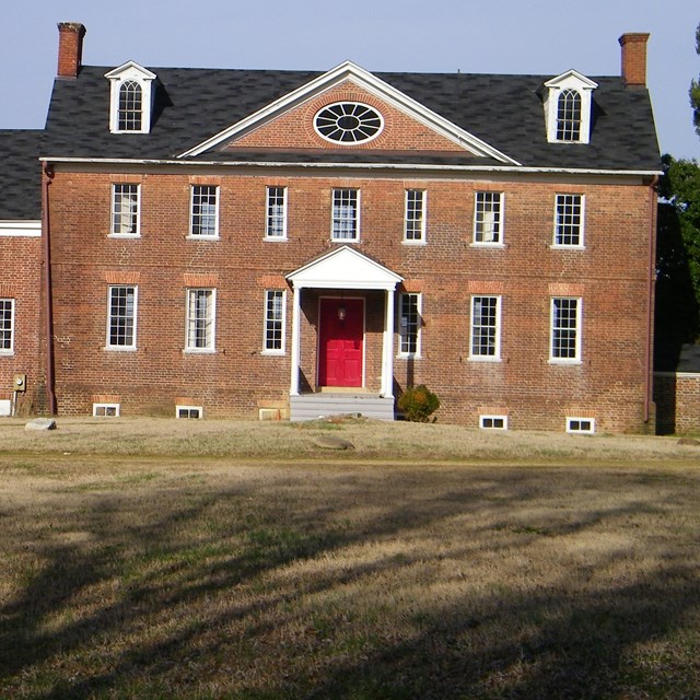 A historic brick mansion with bright red doors