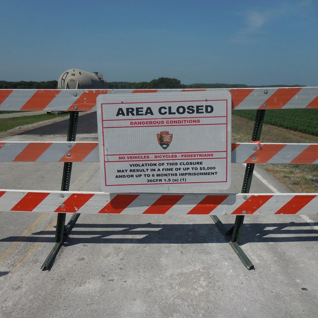 An orange and white barrier with a closed sign