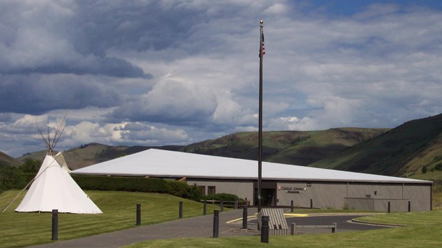 One story building with a white tipi and American flag out front.