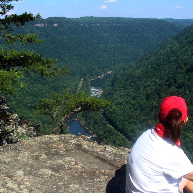 hiker on cliff overlooking gorge