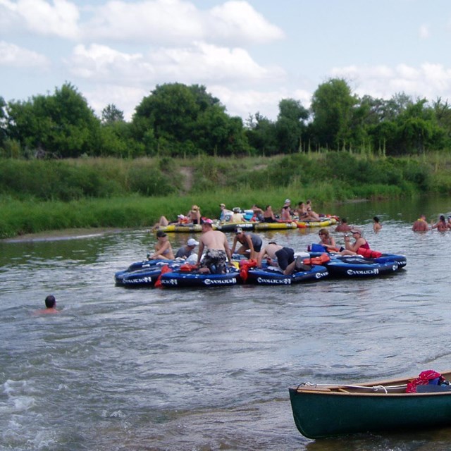 A gathering of tubes on a calm river.