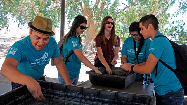 Youth group making seed balls in bins