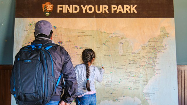 Two visitors looking at a large map of the U.S.