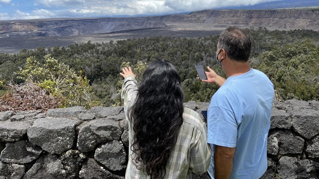 two people looking at mountains while using a cellphone