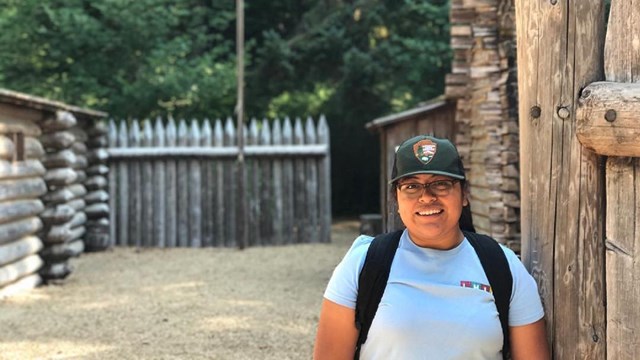 Intern standing inside an old wooden fort