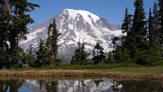 Snow-covered mountain and its reflection in a lake 