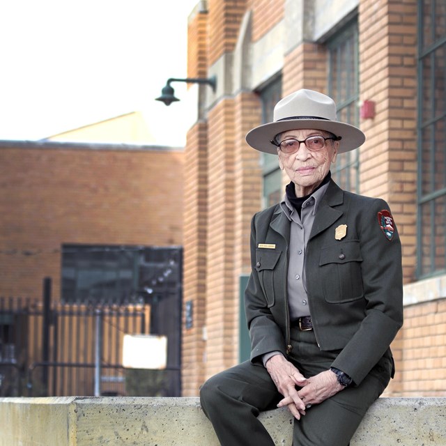 Ranger Betty Soskin sitting near museum exhibits