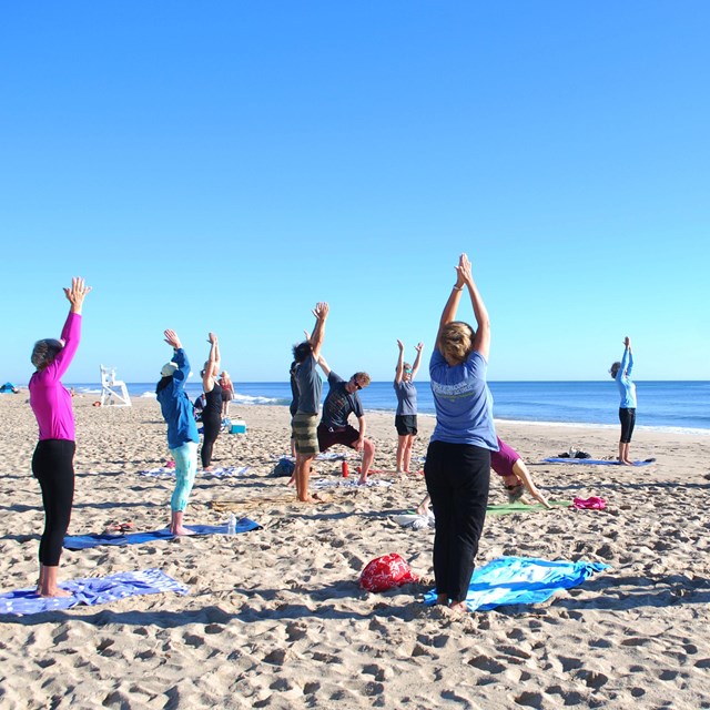 Group doing yoga on the beach