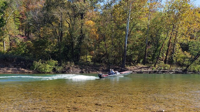 A jonboat glides down a river.