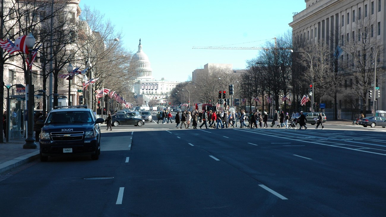 People walking across Pennsylvania Ave