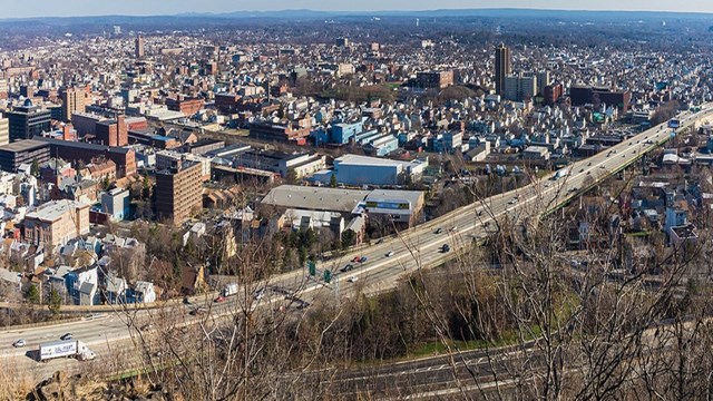 An overhead photo of an urban area with a highway cutting across it