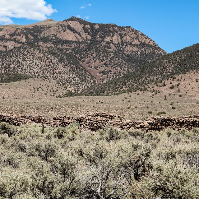 Historic ruins sitting in rolling hills of high desert scrub.