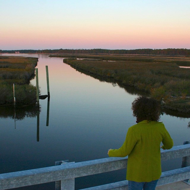 Visitor looks out over Stewart's Canal at dusk, Harriet Tubman Underground RR Nat'l Historical Park