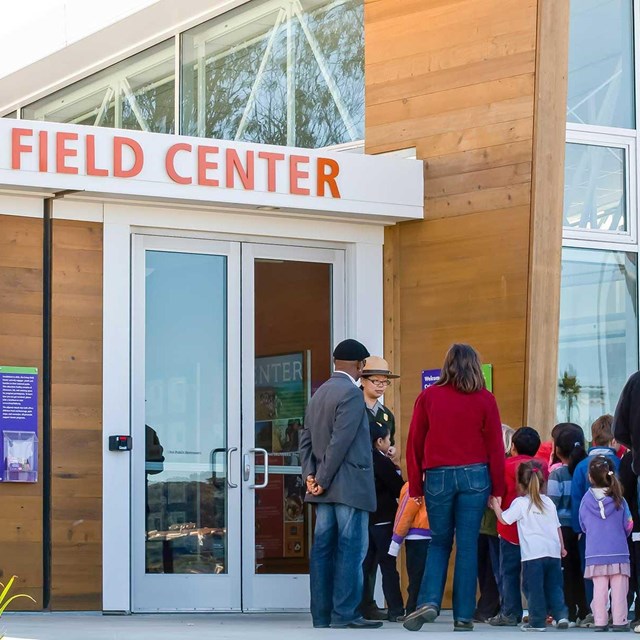 kids and adults in single line outside of center