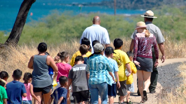 Park ranger leading a group of kids along the trail
