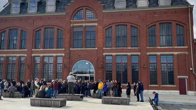 A ranger addresses a group of visitors outside the Visitor Center