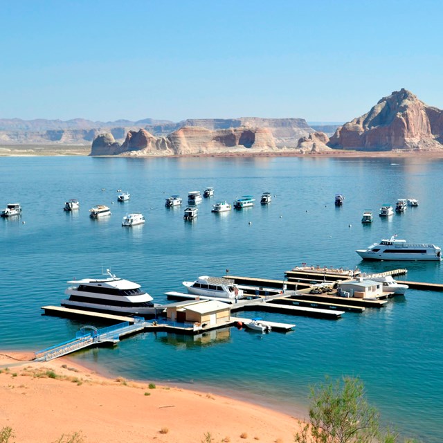 Overview shot of large white boats in and around docks.