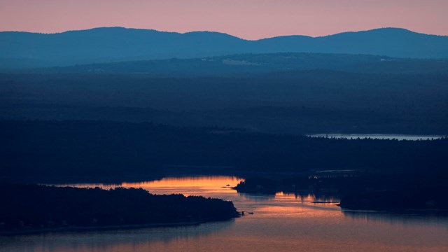 The setting sun over Downeast Maine National Heritage Area from a distance.