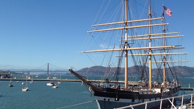 A restored historic sailing ship built in 1886 moored along a pier.