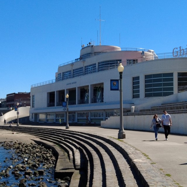 a white building designed to look like an ocean liner ship near a rocky shoreline