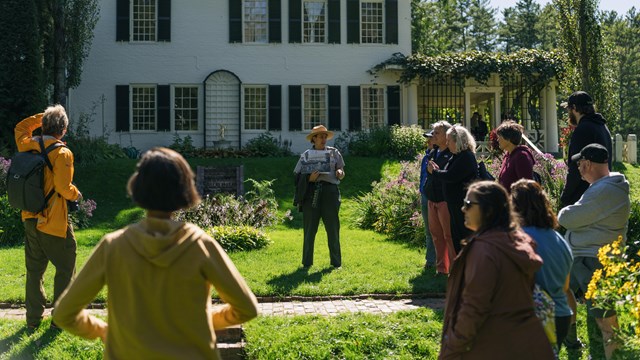 Park ranger showing historic photo in garden