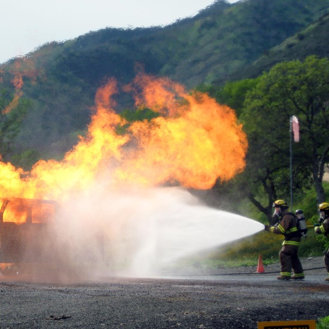 Firefighters put out a simulated car fire