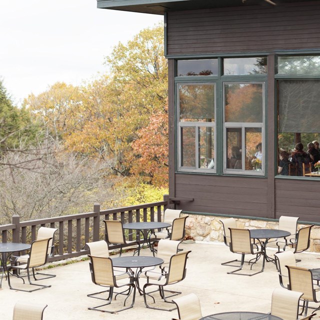 A patio full of tables outside of a restaurant.