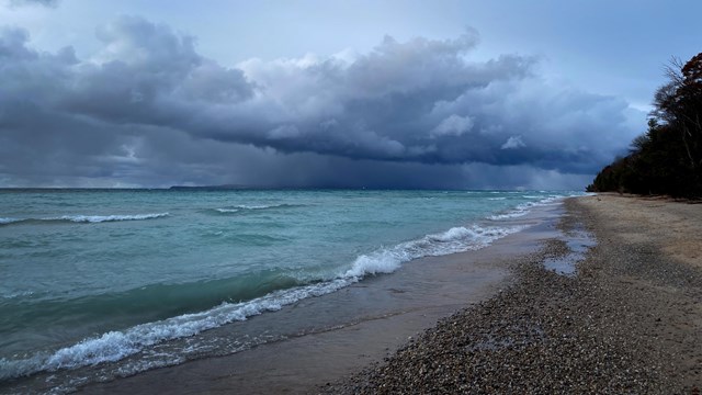 rain clouds over a turquoise body of water.