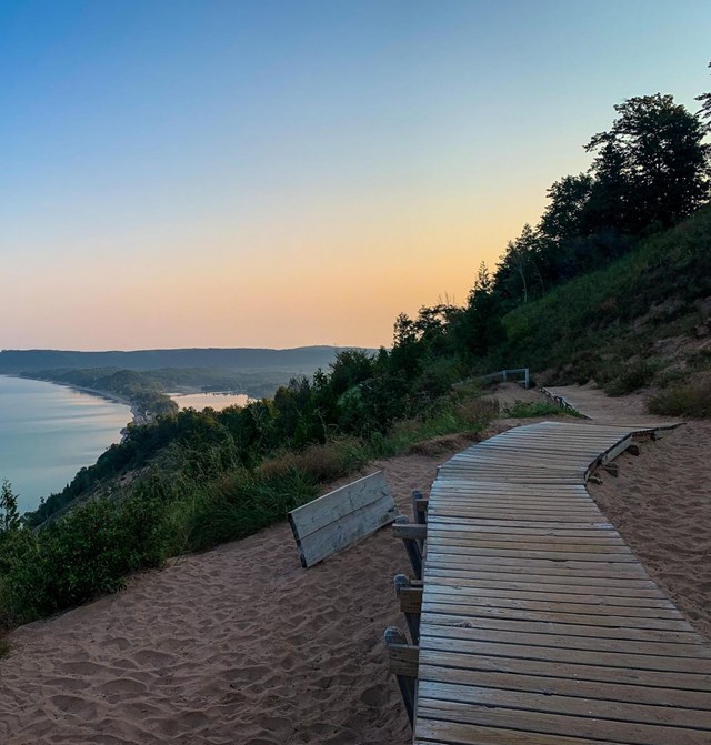 A wooden boardwalk on a high bluff with a view of a large lake beyond.