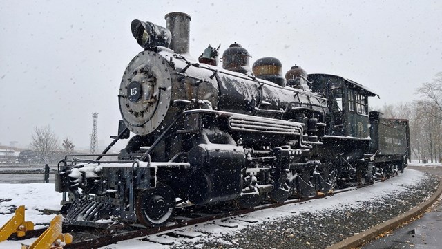 Steam locomotive with a light dusting of snow amid snow flurries