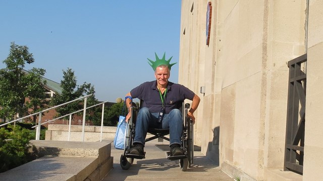 A visitor in a wheelchair is moving down a ramp towards the photographer.