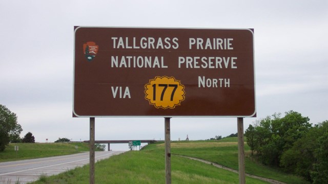 Brown sign near freeway reads " Tallgrass Prairie National Preserve via 177 North"