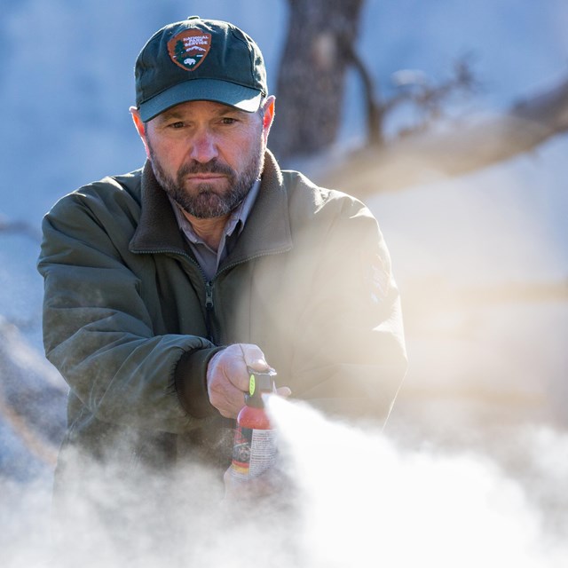 A bear biologist deploys bear spray during a demonstration.