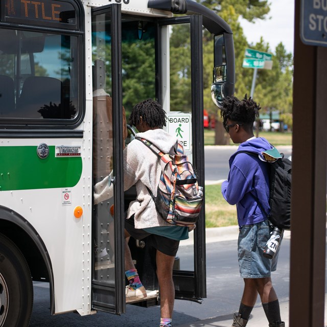 Two visitors board a park shuttle bus.