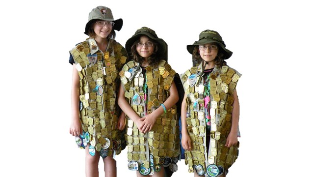 Photograph of three female junior rangers adorned with junior ranger badges.