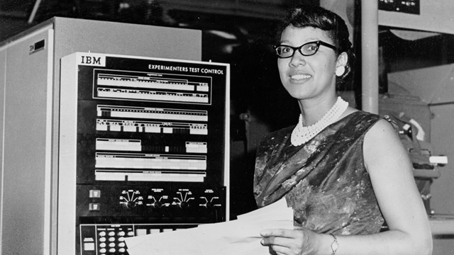 Woman standing by the computer. 