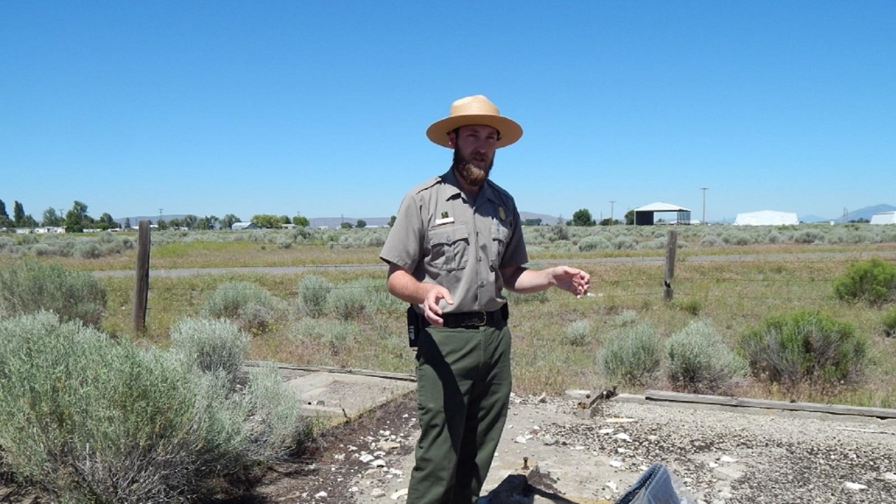 Ranger stands outside next to a paper display