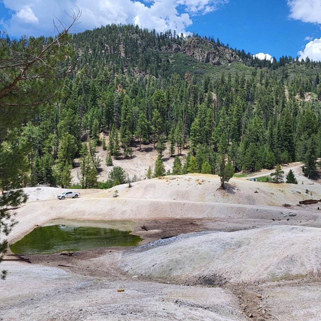 A volcanic landscape composed of white gravel and bright pools of water.