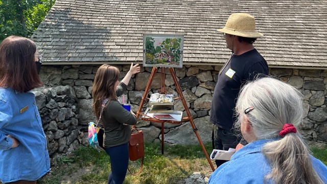 4 artists discuss work of art on easel outdoors at Weir Farm NHP