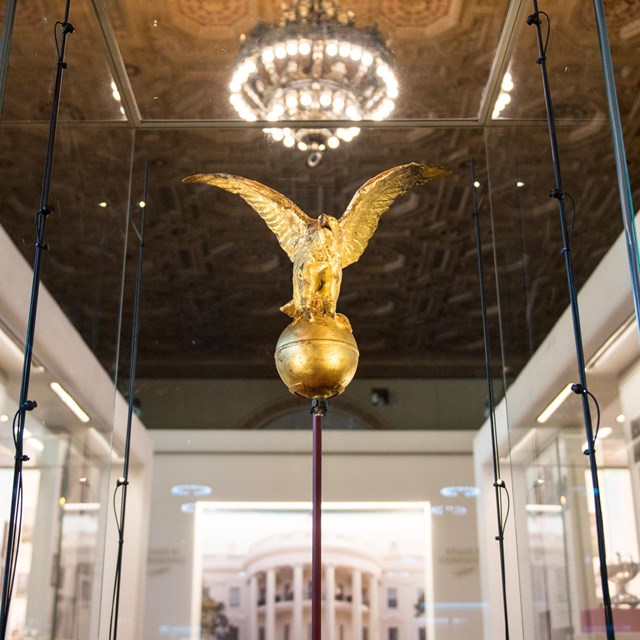 Gold eagle flag topper and image of White House South Portico