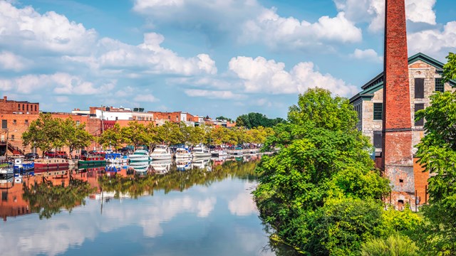 A canal flanked by buildings on a sunny summer day.