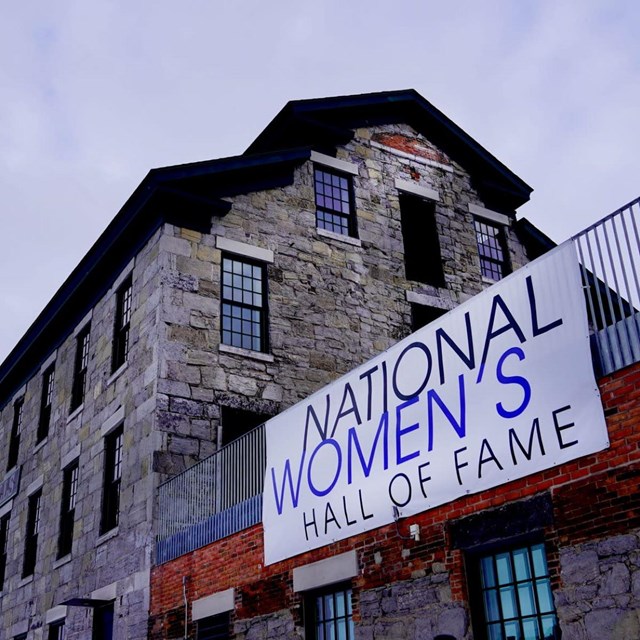A large stone building with a sign reading 