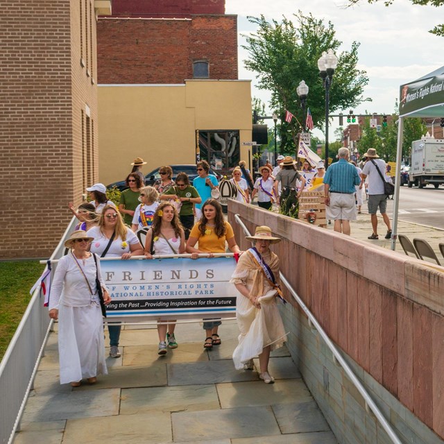 A group of people leading a procession carrying a banner