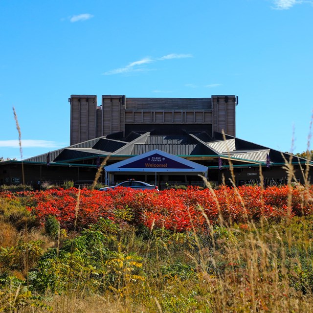 The Filene Center in the background and fenced native garden in the foreground