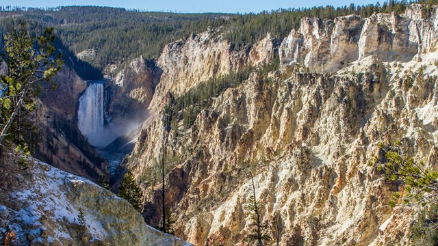 Lower Falls plunges into the yellowish-tan canyon.