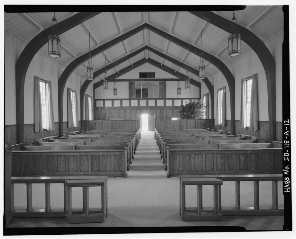 Church with white paneling and dark colored steeple.